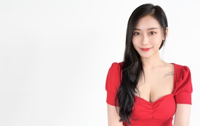 Beautiful Asian girl in a red dress on a white background