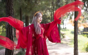 Красивая девушка азиатка в красном национальном костюме 