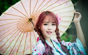 Красивая азиатка в большим зонтом 
