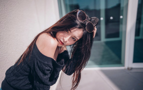 Красивая азиатка в черном свитере с солнечными очками на голове 