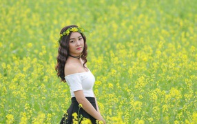 Красивая девушка азиатка на поле с желтыми цветами