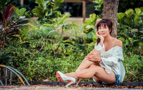 Beautiful asian girl sitting on the ground in a park