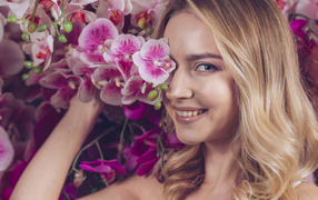 Красивая девушка блондинка с цветами орхидеи
