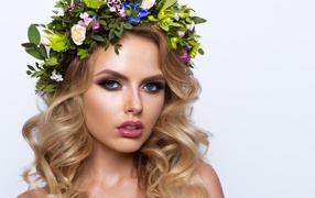 Красивая блондинка с венком из живых цветов на белом фоне