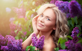 Красивая голубоглазая девушка блондинка в цветах сирени