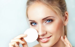 Красивая голубоглазая девушка с ватным диском в руке 