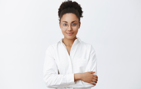 Красивая деловая девушка в белой рубашке и в очках 