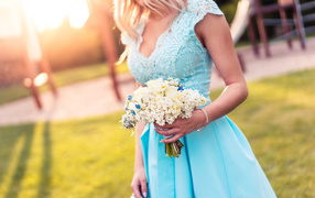 Красивая девушка в голубом платье с букетом в руке