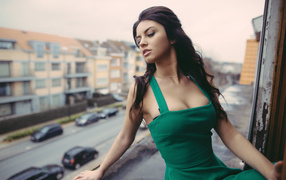 Красивая девушка в зеленом платье на балконе