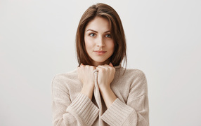 Красивая девушка в теплом свитере на сером фоне 