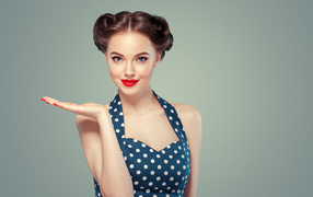 Красивая девушка в платье в горошек на сером фоне