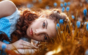 Красивая девушка на земле с мускариками