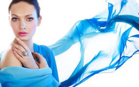 Красивая девушка с голубой накидкой на белом фоне