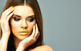 Красивая девушка с желтыми губами на сером фоне