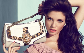 Красивая длинноволосая девушка с сумочкой в руках