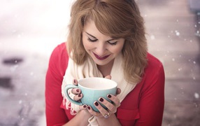 Милая девушка согревается горячим кофе