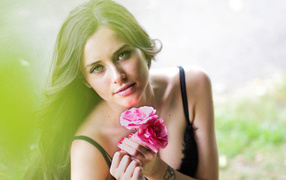 Милая девушка с розовыми цветами лютика в руке