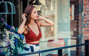 Нежная девушка азиатка стоит на балконе 