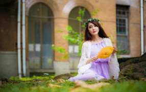 Девушка в красивом платье сидит на траве 