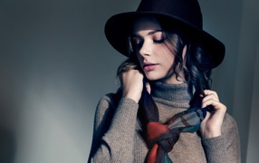 Девушка в сером свитере с платком на шее в черной шляпе