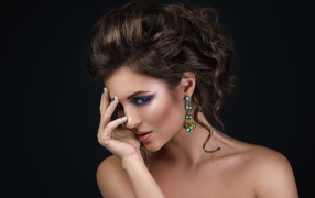 Девушка с красивой вечерней прической на сером фоне