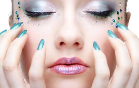 Девушка  с ярким макияжем и стразами на лице 