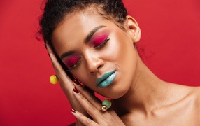 Девушка с ярким макияжем на красном фоне