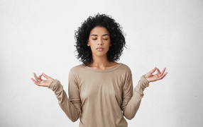 Девушка с закрытыми глазами медитирует 