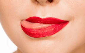 Девушка с  красными губами показывает язык