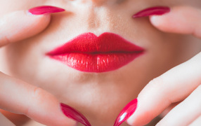 Руки с длинными красными ногтями у губ