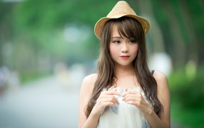 Скромная девушка азиатка в шляпе 