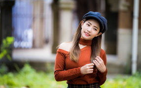 Улыбающаяся азиатка в черной кепке 