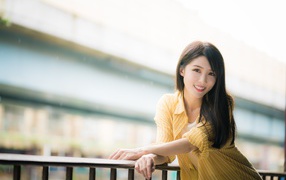 Улыбающаяся азиатка в желтой полосатой рубашке