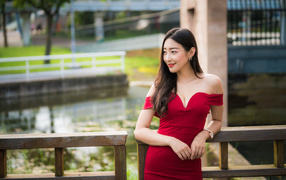 Smiling girl in a red dress at the railing