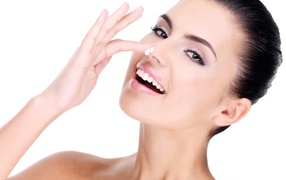 Улыбающаяся девушка мажет крем на нос 