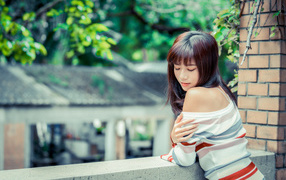 Нежная азиатка стоит на балконе