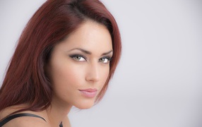 Лицо стильной девушки с зелеными глазами на сером фоне