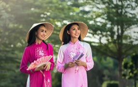 Две девушки азиатки в платьях с веером в руках