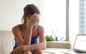 Расстроенная молодая девушка с ноутбуком