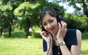 Молодая девушка азиатка в больших наушниках 