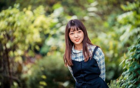 Молодая азиатка в рубашке и черном платье