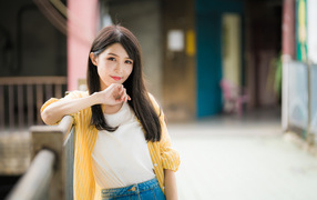 Молодая азиатка в белой майке и полосатой рубашке 