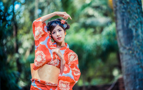 Молодая азиатка в кимоно в парке 