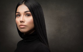 Молодая длинноволосая шатенка на сером фоне