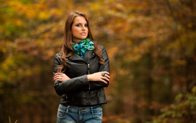 Молодая девушка в черной кожаной куртке  в парке