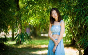 Young girl in a blue suit under a tree