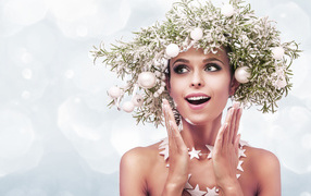 Beautiful girl with a Christmas wreath on her head on a white background
