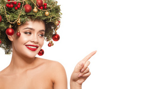 Smiling girl with a wreath of fir branches on her head on a white background