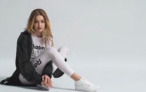 Американская супермодель Джиджи Хадид в спортивном костюме сидит на полу