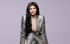 Длинноволосая модель Кайли Дженнер в костюме на сером фоне